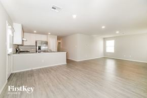 Converse house for rent - A spacious kitchen with white cabinets and a wooden floor.
