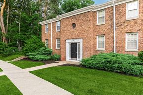 Ithaca apartment for rent - the front of a brick building with a sidewalk and grass