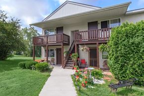Mechanicville apartment for rent - a house with a walkway and a bench in front of it