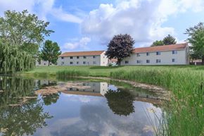 Mechanicville apartment for rent - the building in which the hotel is located is reflected in a pond