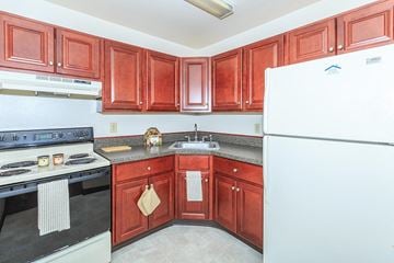 Mechanicville apartment for rent - a kitchen with wooden cabinets and a white refrigerator