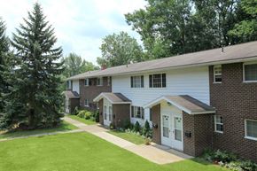 Oneonta apartment for rent - a white and brick house with a yard and a tree