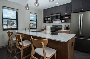 Detroit apartment for rent - a kitchen with a marble counter top and wooden chairs