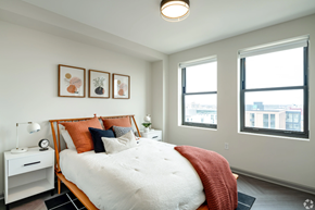 Detroit apartment for rent - a bedroom with a bed and two windows