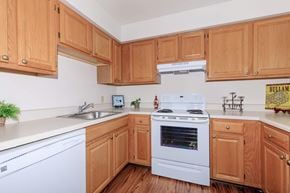 Troy apartment for rent - a kitchen with white appliances and wooden cabinets