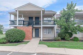 Troy apartment for rent - the front of an apartment building with a porch and a walkway