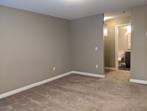 Regina apartment for rent - A room with a carpeted floor and a doorway leading to another room.