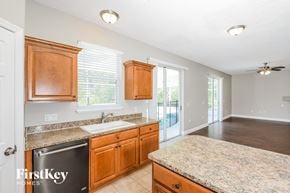Orlando house for rent - a kitchen with wooden cabinets and granite counter tops