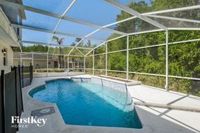 Orlando house for rent - a swimming pool in a pool house with a glassed in pool