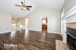 Clarksville house for rent - a living room with a fireplace and a ceiling fan