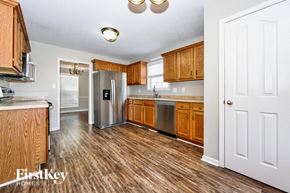 Clarksville house for rent - a kitchen with wooden cabinets and a stainless steel refrigerator