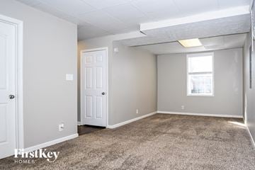 Clarksville house for rent - the living room of an apartment with carpet and a white door