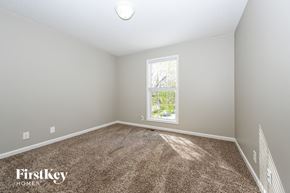Clarksville house for rent - a bedroom with a carpeted floor and a window