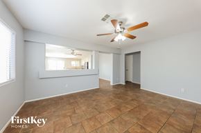 Phoenix house for rent - an empty living room with a ceiling fan and tile flooring