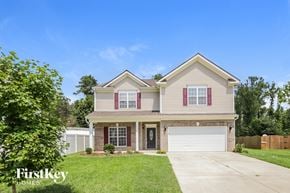 Greensboro house for rent - a beige house with red shutters and a white garage door