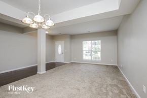 Greensboro house for rent - an empty living room with a chandelier and a window