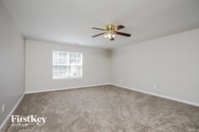 Greensboro house for rent - a bedroom with carpet and a ceiling fan