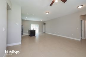 Poinciana house for rent - A spacious room with a ceiling fan and a large window.