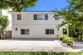 West Hollywood apartment for rent - A white building with a grey roof and a fence in front.