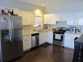 Chicago apartment for rent - a kitchen with white cabinets and stainless steel appliances