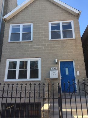 Chicago apartment for rent - a brick house with a blue door and a gate