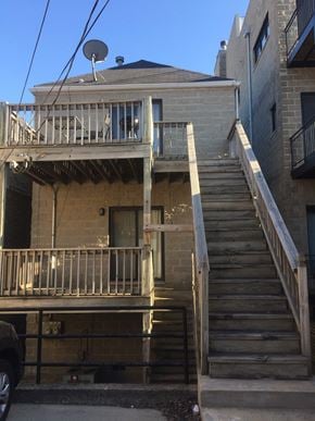 Chicago apartment for rent - the back of a brick building with stairs and a balcony