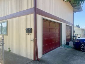 Kelso apartment for rent - a garage with a red door and a car parked next to it