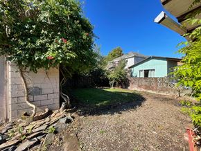 Kelso house for rent - a backyard with a green house and a brick wall and a tree