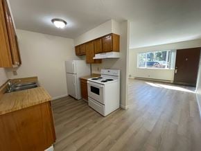 Kelso apartment for rent - A kitchen with a white refrigerator, white stove, and wooden cabinets.