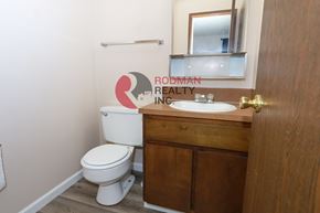 Longview apartment for rent - A bathroom with a toilet, sink and Rodman Realty Inc. logo.