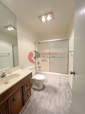 Longview apartment for rent - A bathroom with a toilet, sink, and mirror.