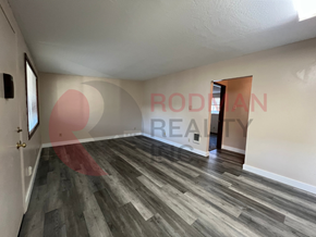 Longview apartment for rent - A room with wooden flooring and a doorway leading to another room.