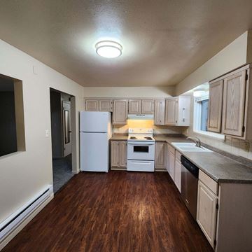 Longview apartment for rent - a kitchen with wooden floors and white appliances