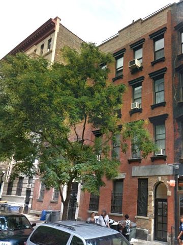 New York apartment for rent - a tall brick building with a tree in front of it