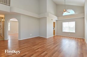 Tucson house for rent - an empty living room with hardwood floors and a ceiling fan