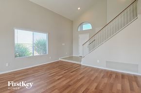 Tucson house for rent - the living room and entryway of a house with hardwood floors and a staircase