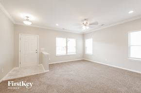 Charlotte house for rent - a spacious living room with a ceiling fan and a white door