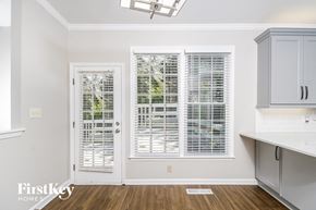Greensboro house for rent - a kitchen with white cabinets and a door with white plantation shutters
