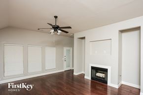 Crowley house for rent - a living room with a ceiling fan and a fireplace
