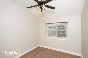 Crowley house for rent - a bedroom with a ceiling fan and a window