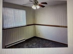 Rochester apartment for rent - A room with a ceiling fan and a window.