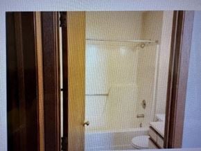 Rochester apartment for rent - A bathroom with a toilet and a glass shower door.