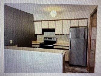 Rochester apartment for rent - A kitchen with a refrigerator, microwave, and oven.