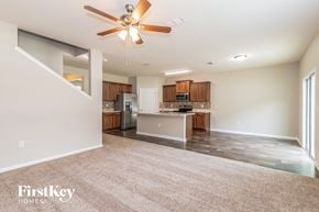 Jacksonville house for rent - an empty living room and kitchen with a ceiling fan