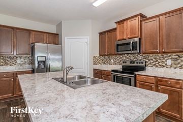 Jacksonville house for rent - a kitchen with wooden cabinets and granite counter tops and a sink