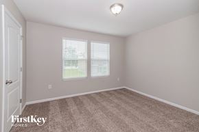 Jacksonville house for rent - a bedroom with carpet and two windows and a door