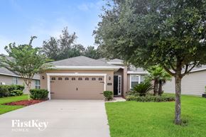 Jacksonville house for rent - a home with a garage door and a lawn