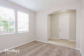 Jacksonville house for rent - a bedroom with a door and two windows and a carpeted floor