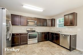 Winston Salem house for rent - a kitchen with dark wood cabinets and stainless steel appliances