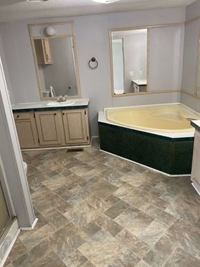 Eunice house for rent - a bathroom with a tub and a sink and a mirror